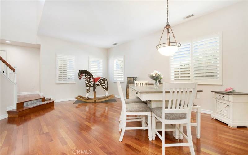 Formal living and dining graced with hardwood flooring and plantation shutters.