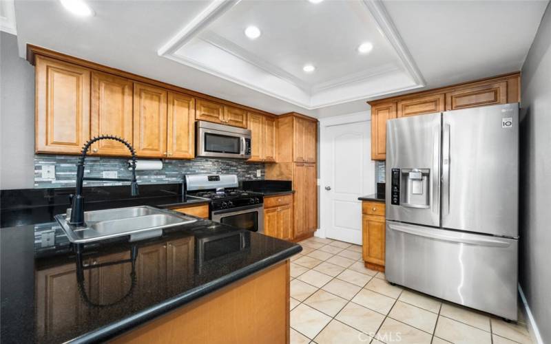 Nicely remodeled kitchen with stone countertops and updated recessed lighting.