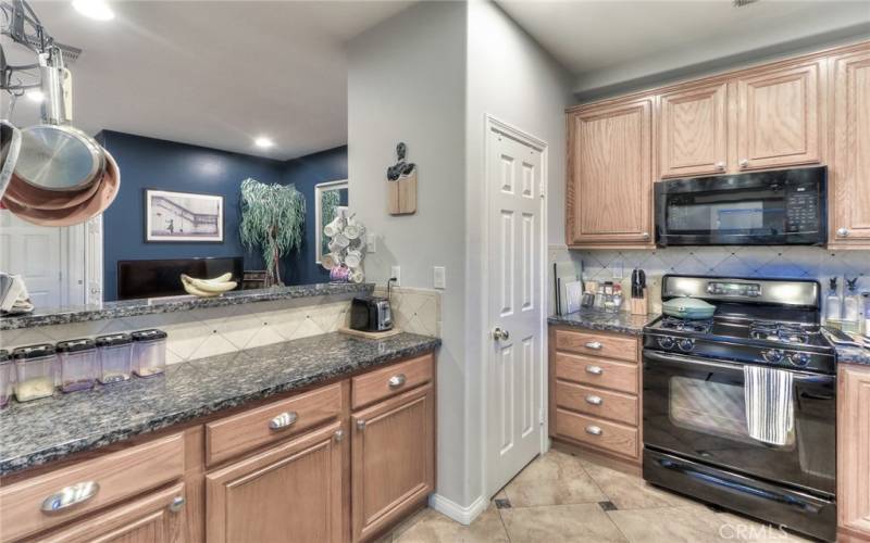 Kitchen with granite countertops and tile backsplash, open to living room