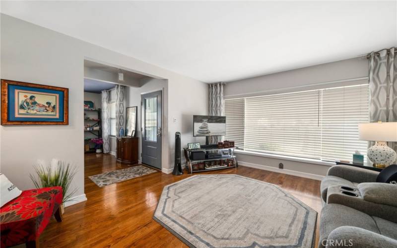 Reverse angle to the spacious living room with beautiful hardwood floors throughout and freshly painted interiors