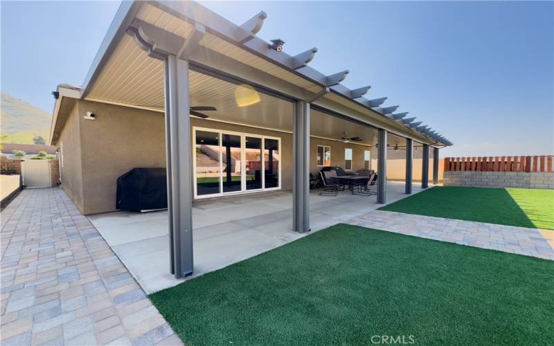 Full length covered patio with 4 ceiling fans with lights. Multicolored walk way pavers