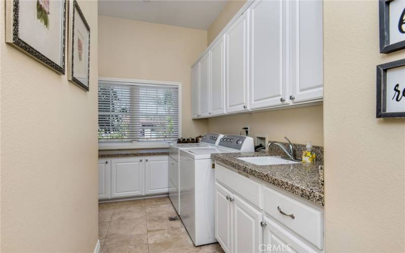 There are two laundry rooms, one on each floor. This fully equipped room has ample storage space and leads to the garages.