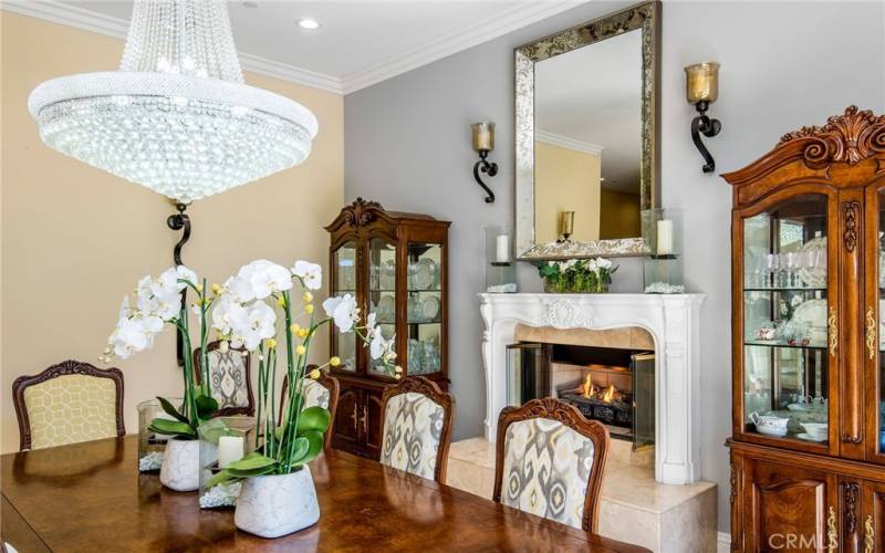 The formal dining room features a gas fireplace and beautiful crystal chandelier.