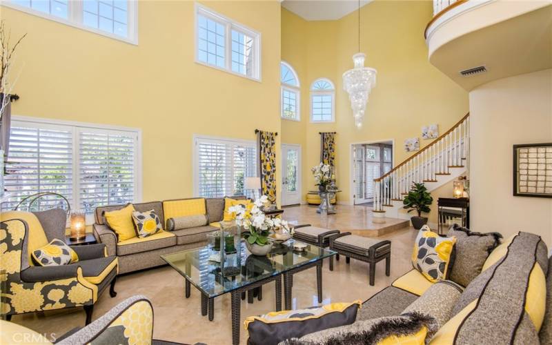 Sunlight spills into the living room with it’s double height ceiling. The professional decorating highlights the sunniness of this cheerful room.