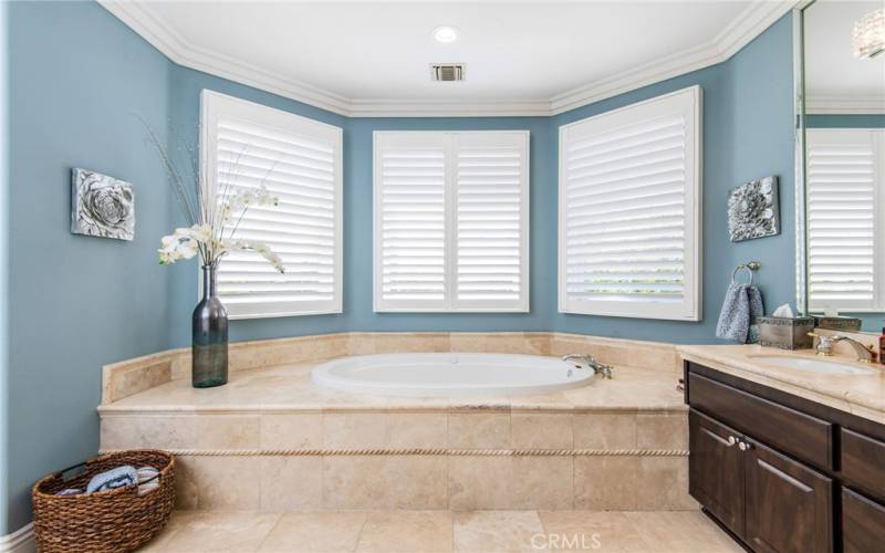 A jetted soaking tub with windows overlooking the backyard.