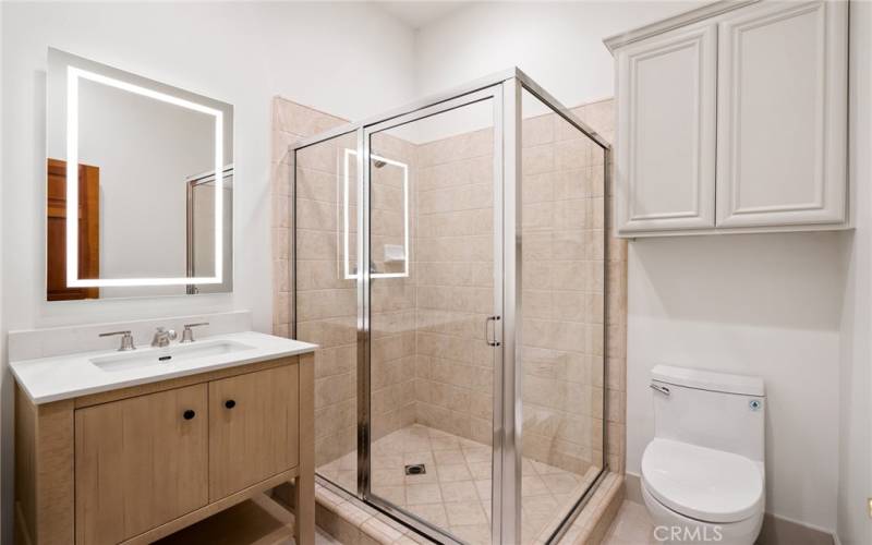 This bathroom offers a tiled shower and new vanity with quartz countertop