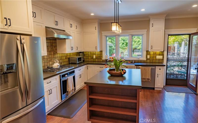 Remodeled chef's kitchen with oversized island, stainless appliances, wine fridge, fresh cabinets.