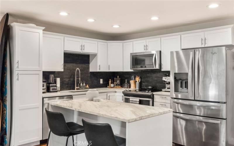 The beautifully upgraded kitchen with stainless steel appliances and an island and breakfast bar.