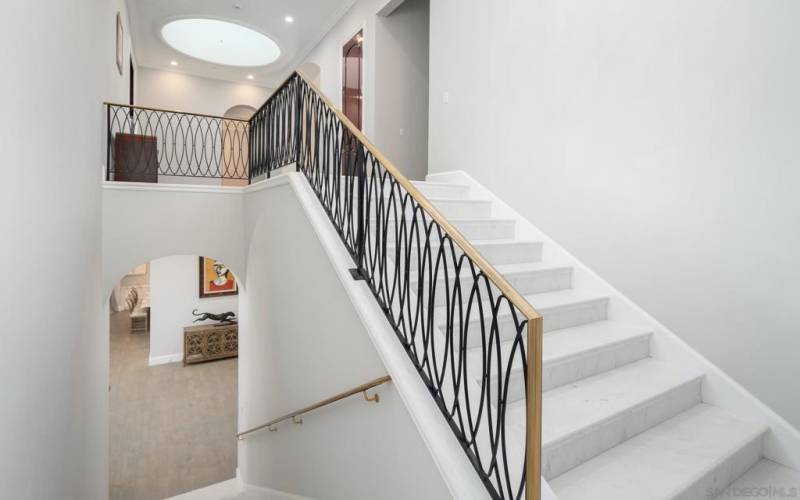 Wide white marble stairs and solid brass railings.