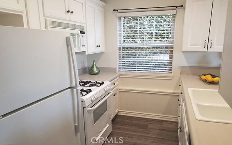 Kitchen with ample cabinet and counter space, refrigerator included.