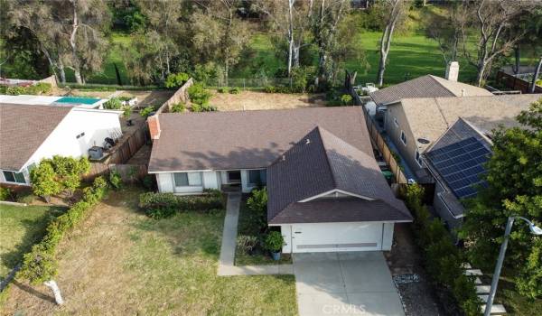 Arial photo of house, large lot, with golf course behind the property.