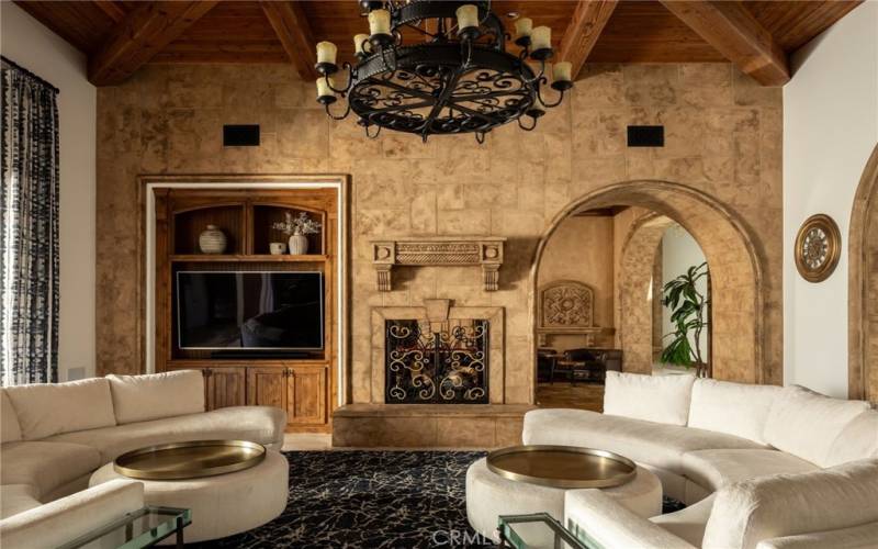 Family Room with fireplace and stone archways to Billards and Bar area