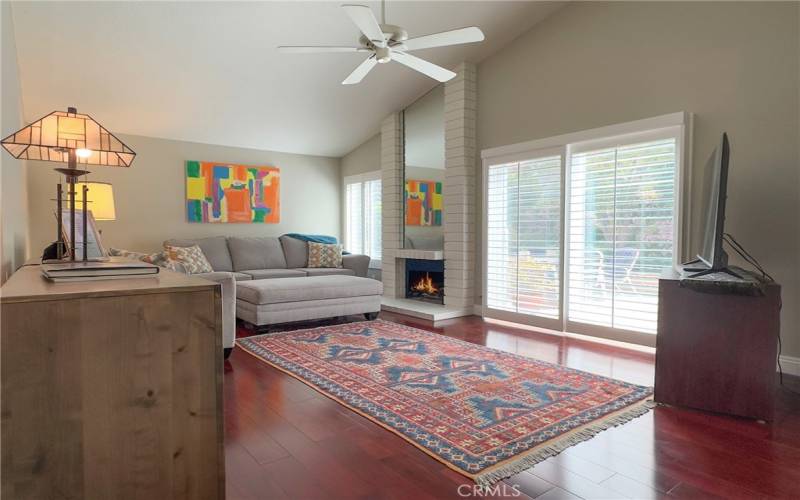 Living Room area with fireplace, custom shutters on all newer windows, laminate wood flooring.  A feeling of light and airy spacious room to enjoy the day or cozy evenings.