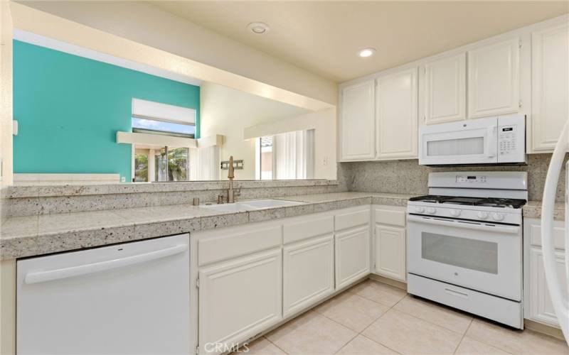 Kitchen with upgraded countertops, backsplash, faucet, dishwasher and flooring