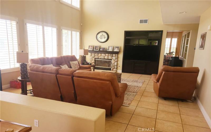 Lovely open family room with fireplace and plantation shutters