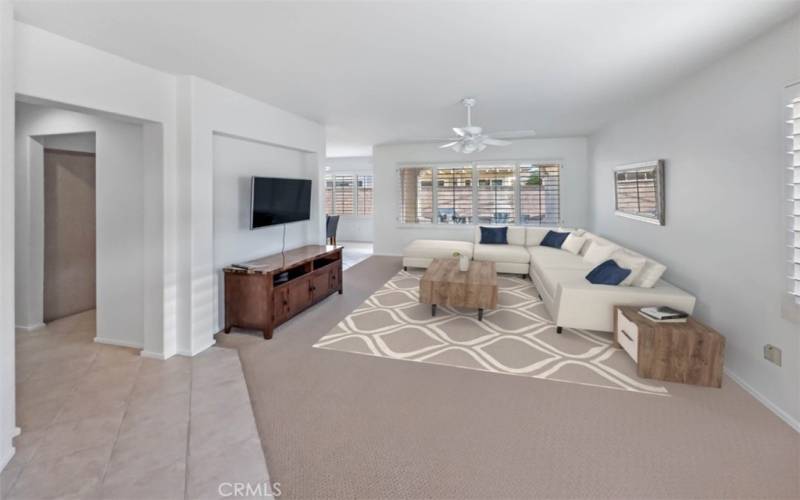 Virtually staged bright living room entrance with custom plantation shutters