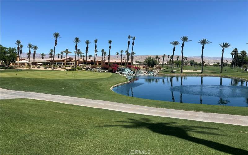 Clubhouse overlooking one of the many lakes and golf course on a sunny desert day.