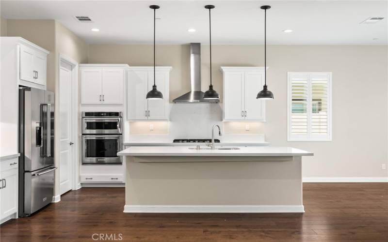 Upgraded kitchen with white hardwood cabinetry, stainless steel appliances, pendant lighting and more - this space is perfect for entertaining!
