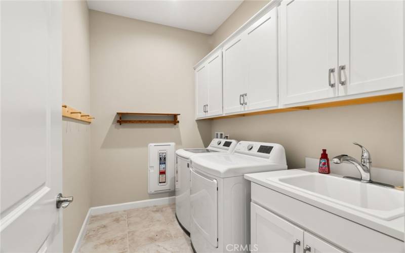 This large laundry room has built in cabinetry and a large utlity sink - perfect for home projects.