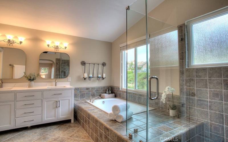 A divine Master bath has tall ceilings with a soaking tub and separate glass shower and walk-in closets is the ultimate in luxury and style.