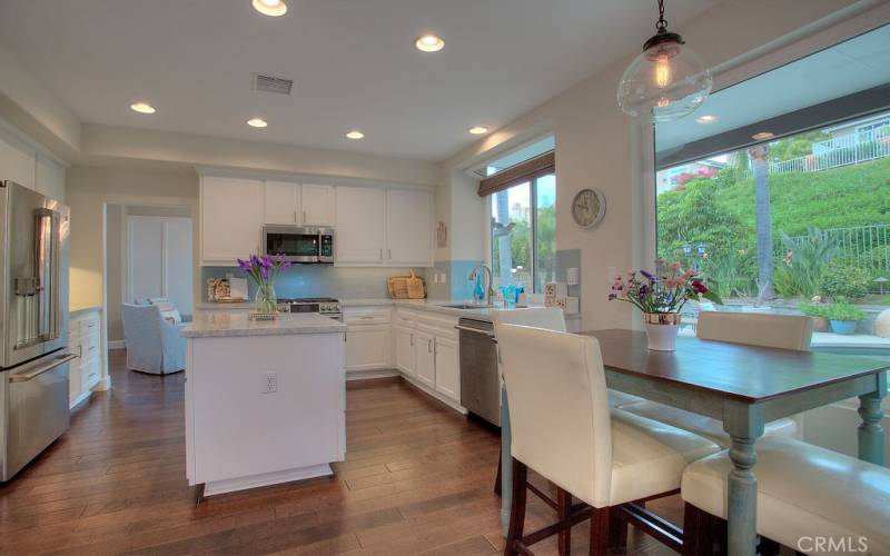 Classic white cabinets enhance this spacious Kitchen layout with recessed lighting