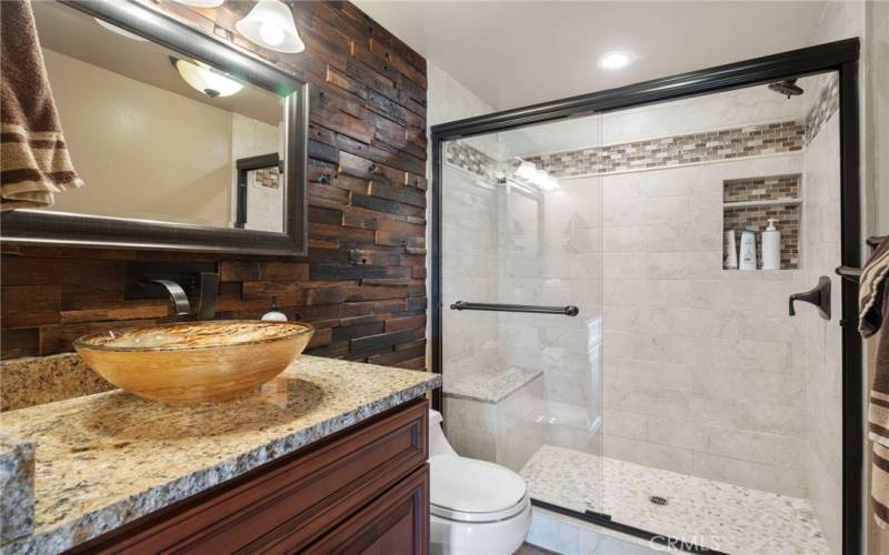 Downstairs Bath, remodeled large Shower with stone countertop, stacked stone wall and pebble tile shower floor