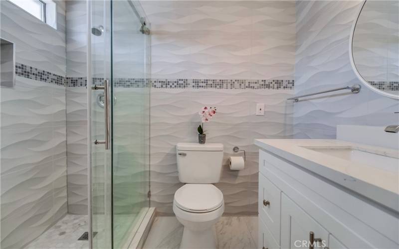 2nd bath is across from 4th bedroom and is sure to impress with more custom tile, walk-in shower, and stylish vanity