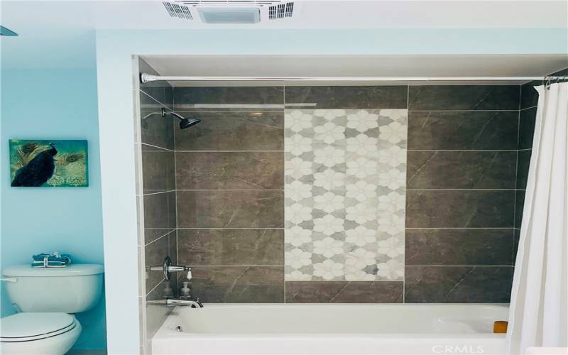 Glazed tub/shower has exquisite Italian natural stone and tile design