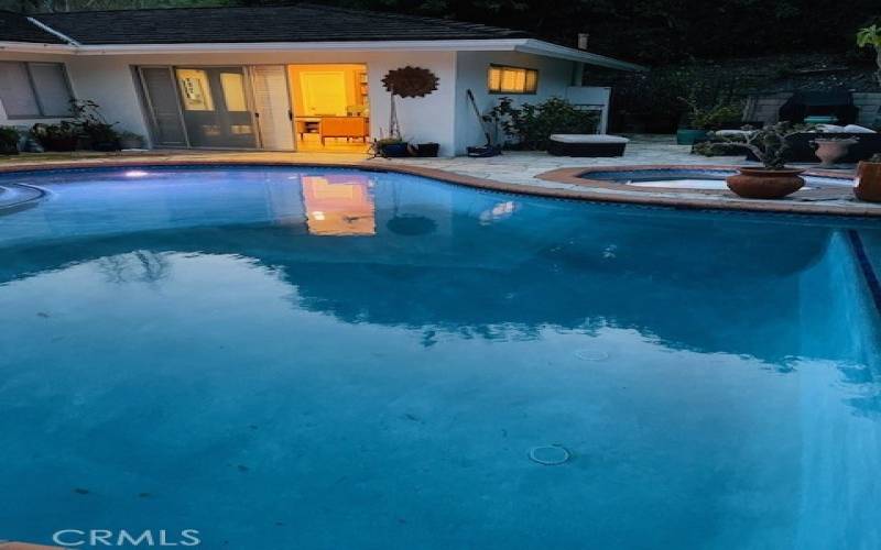 Twilight view of pool and primary bedroom