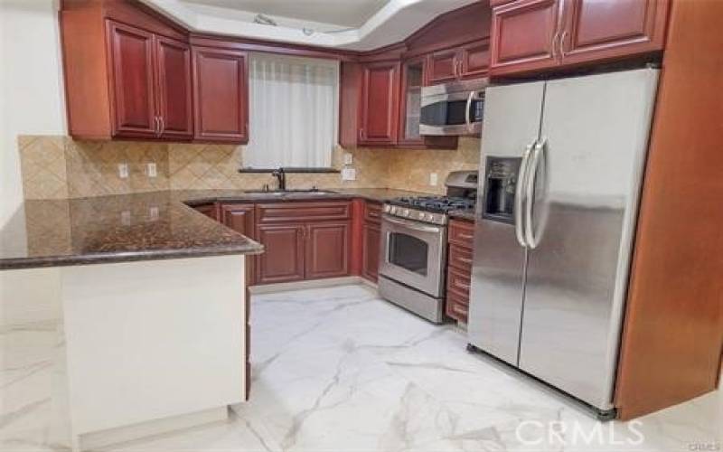 Kitchen w/ stainless steel appliances, greanite counter, Carrarra Marble floors