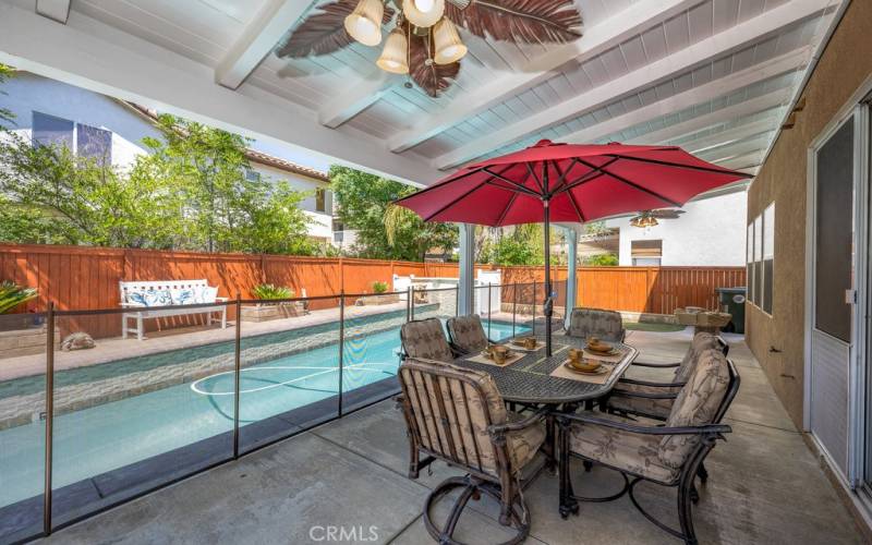 Saugus California home for sale pool view from under porch with a ceiling fan installed pool has a heater and this house is located on a cul-de-sac