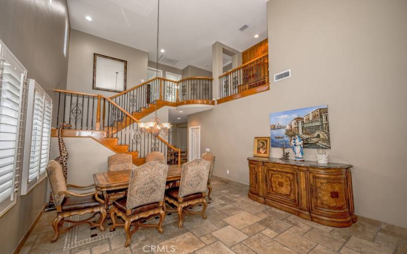 Formal room, dining space, view upstairs in floorplan with high ceilings and upstairs perch overview.