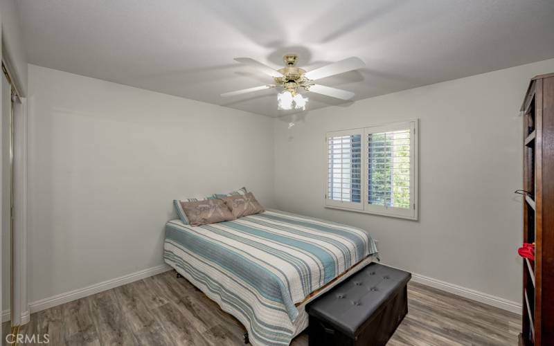 One of the 4 larger bedrooms, well appointed with view of backyard, pool and ceiling fan.