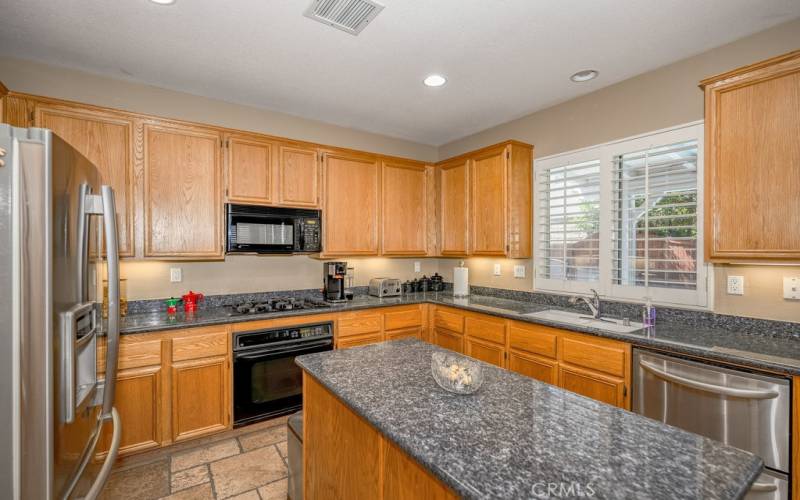 Large kitchen with custom granite and well maintained cabinets with high value windows.