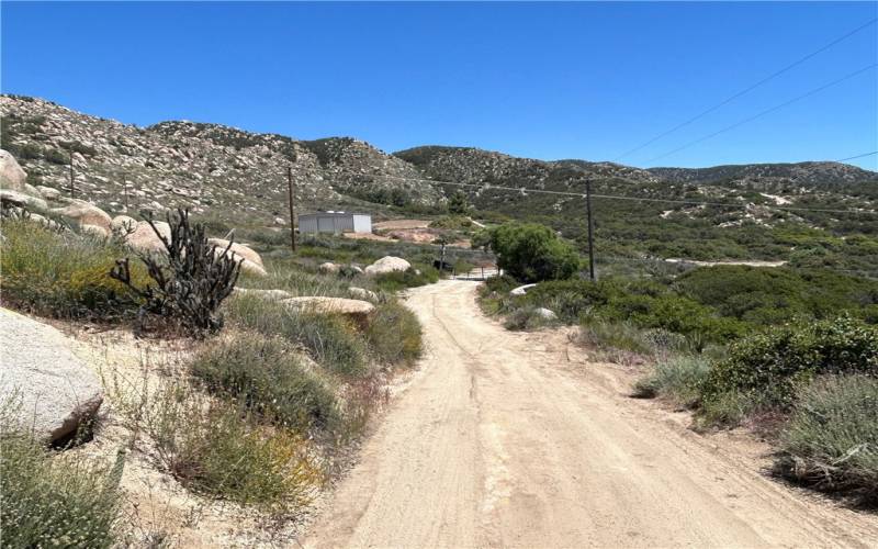 East facing inner road to SE corner of property showing grey double ranch gates.