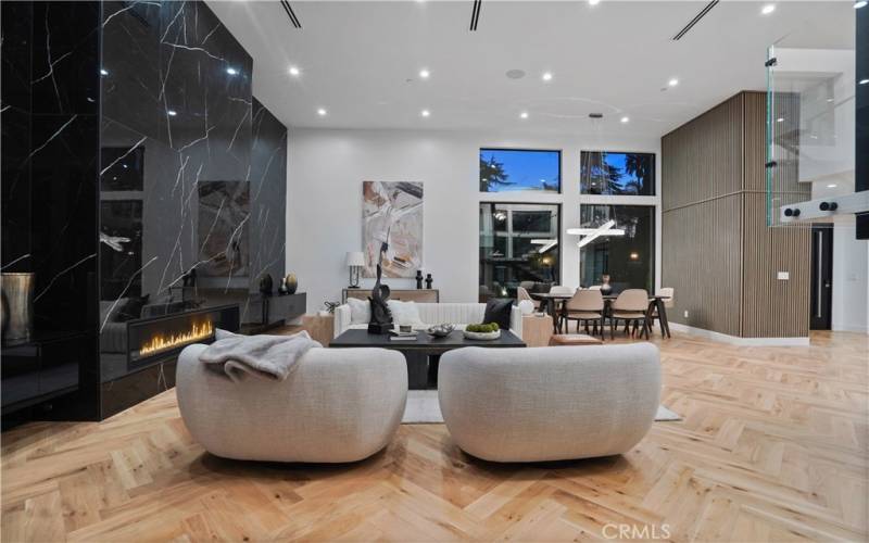 Great Room w / Massive Wall-to-wall Quartz  Fireplace & a Big Picture Window overlooking Beautiful  Courtyard