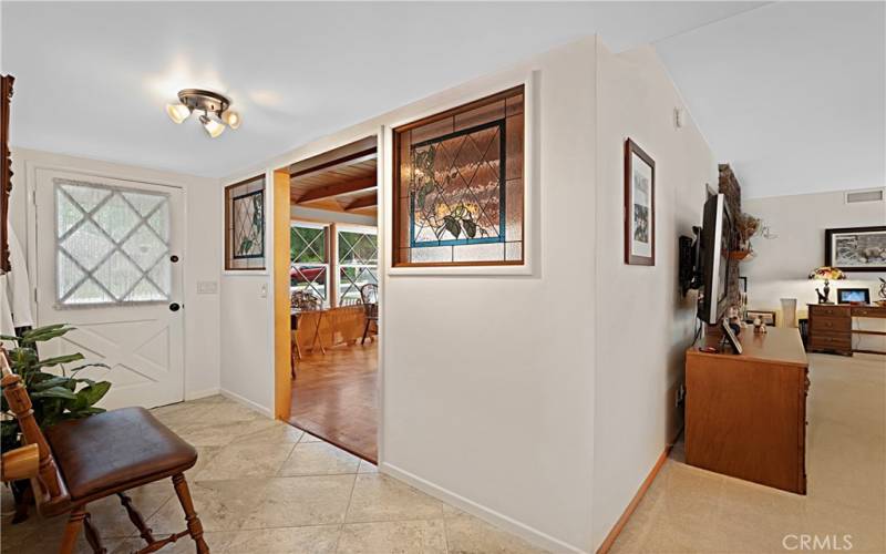 The entry way leads to the dining room, and living room. Notice the custom stained glass accents.