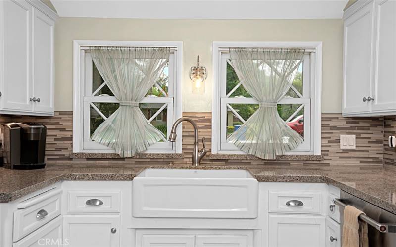 The oversized farmer style sink has a lovely view to the front yard.