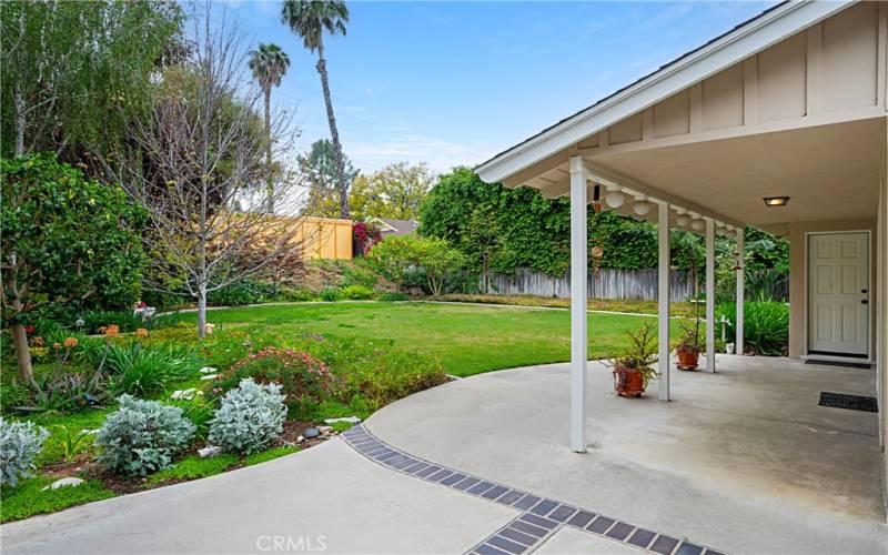 the backyard features lovely gardens and a grassy area for play.