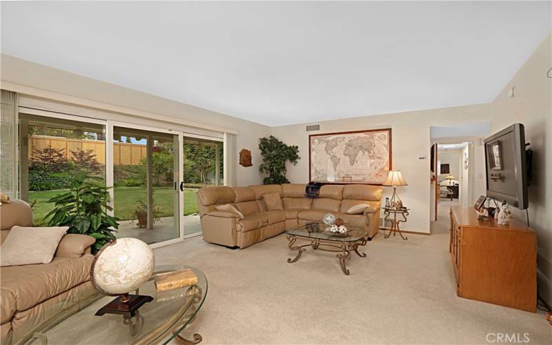 the large sliding door wall brings in natural light and has access to the covered back patio.