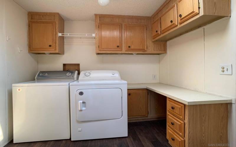 Full size laundry room with storage cabinetry.