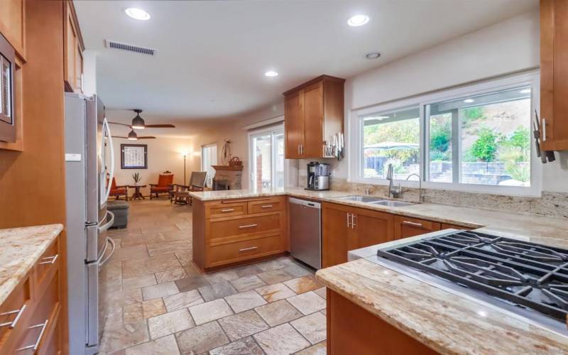 Gourmet kitchen with 4 burner Wolf gas stove. Tons of light offered with views of the Pool.