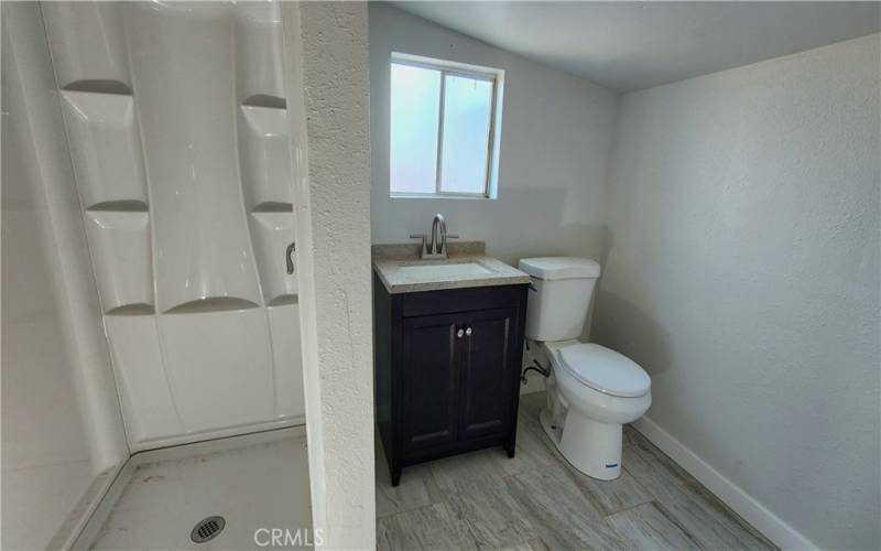 ADU bathroom with shower, vanity sink and toilet.