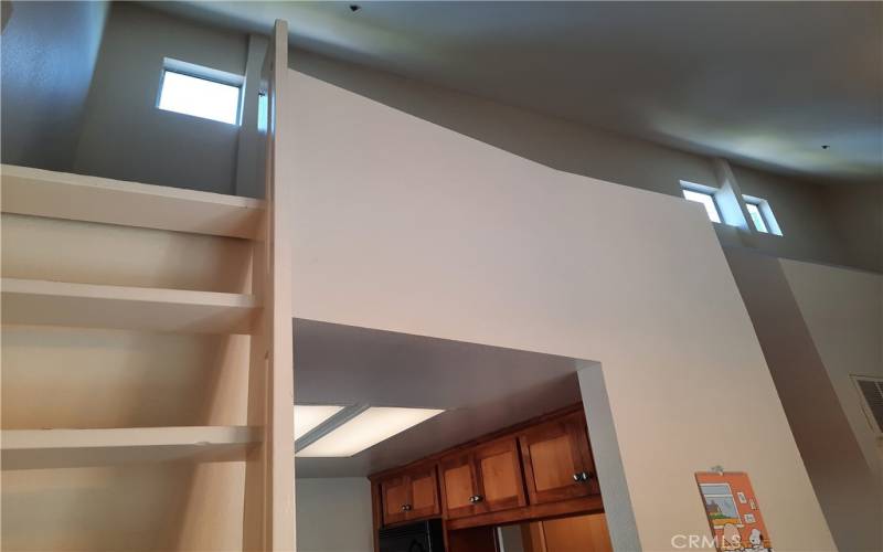Stairs leading from dining area to loft over kitchen.