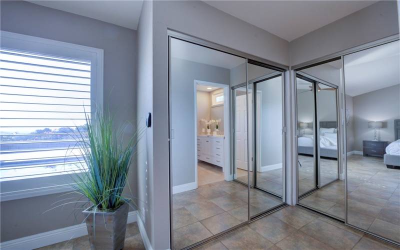 Dual custom designed mirrored closets in the primary bedroom.