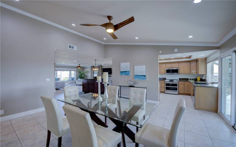 Roomy formal dining room has vaulted ceiling, crown molding, recessed lighting and stunning lighted ceiling fan.