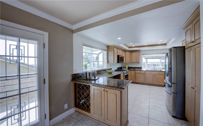 Bright and airy kitchen with recessed lighting, garden window, breakfast bar, pantry, wine rack and lots of storage.