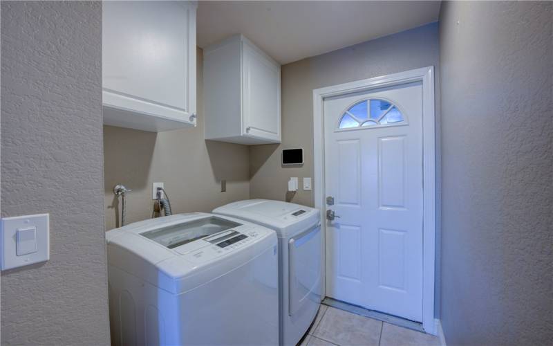 Convenient Inside Laundry Area and the door to the two car garage with custom designed cabinetry.