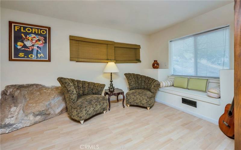Downstairs apartment has a living room with its sitting area and window seat.