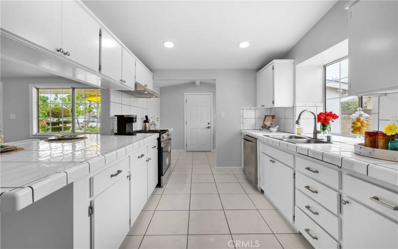 Cheerful white kitchen with new stainless oven, hood, brush n